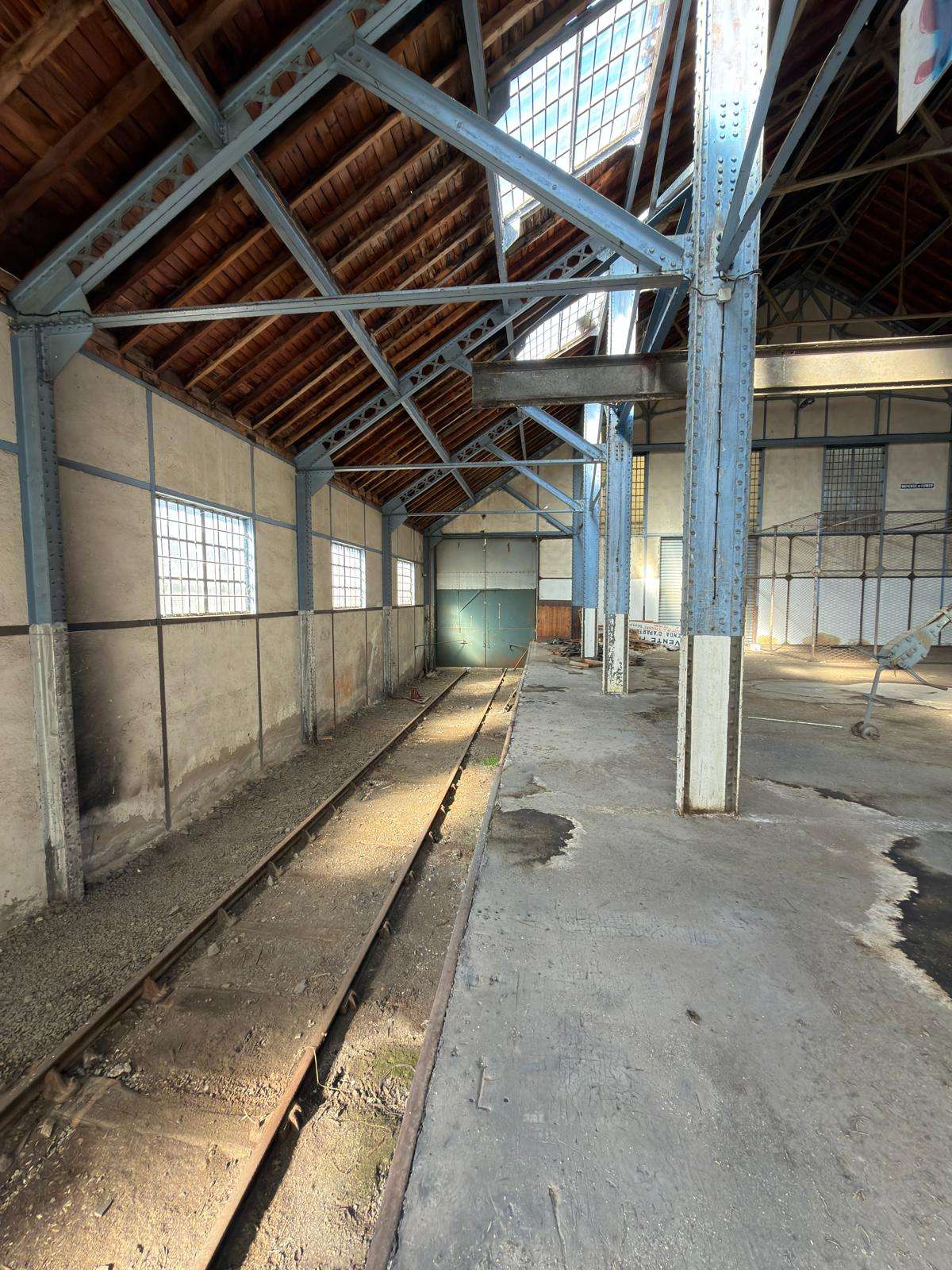 Intérieur de la Halle Subra, vue sur les voies ferrées et la plateforme en béton